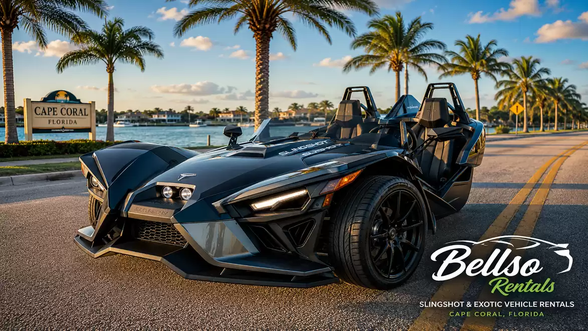 A black three-wheeled motor vehicle is on a street by the water with palm trees in the background in Cape Coral, Florida, at sunset.