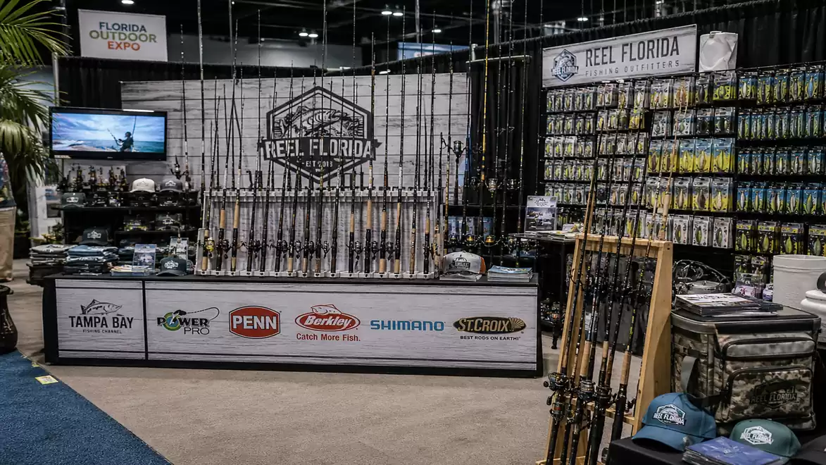 A trade booth of Reel Florida showcasing a variety of fishing rods and accessories at the Florida Outdoor Expo.