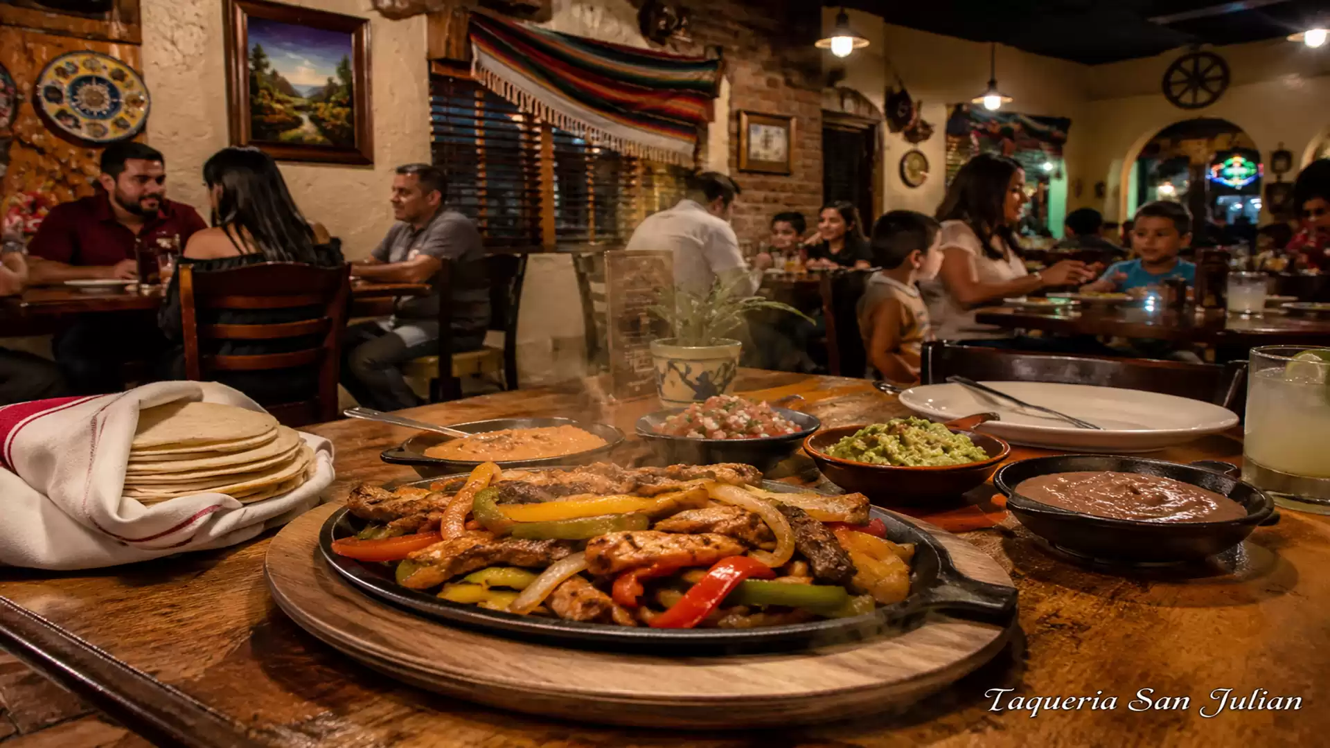 A Mexican restaurant with a table full of colorful dishes and diners in the background in traditional decor.
