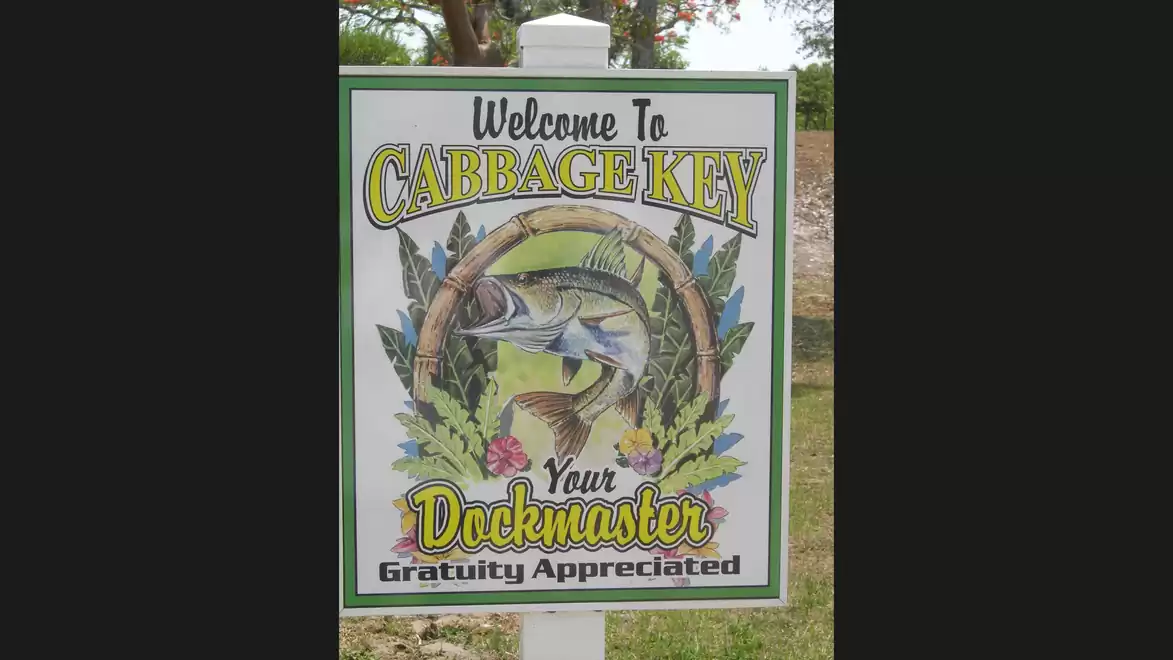 Welcome sign on Cabbage Key featuring a fish design with the phrase 'Gratuity Appreciated'.