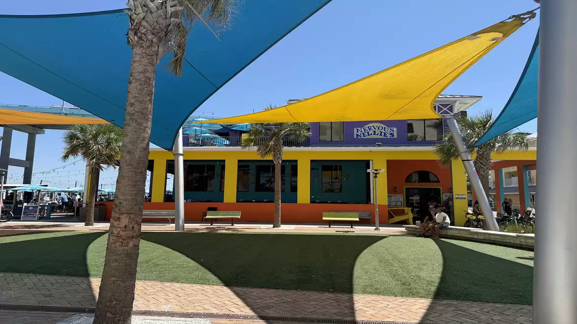 A colorful building with yellow and blue sunshades on a sunny day.