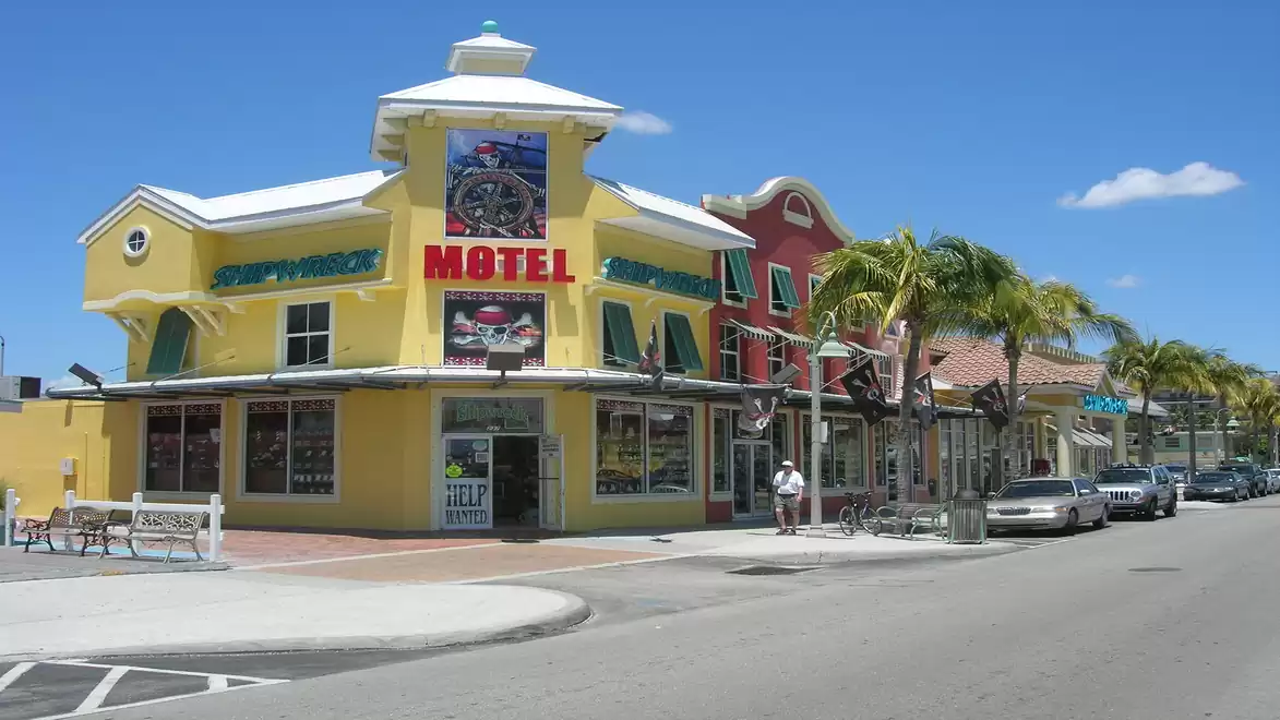 Street view of a colorful motel with palm trees on a sunny day.