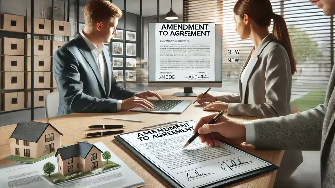 Two people working on a computer reviewing contract amendments, with a model house on the table.
