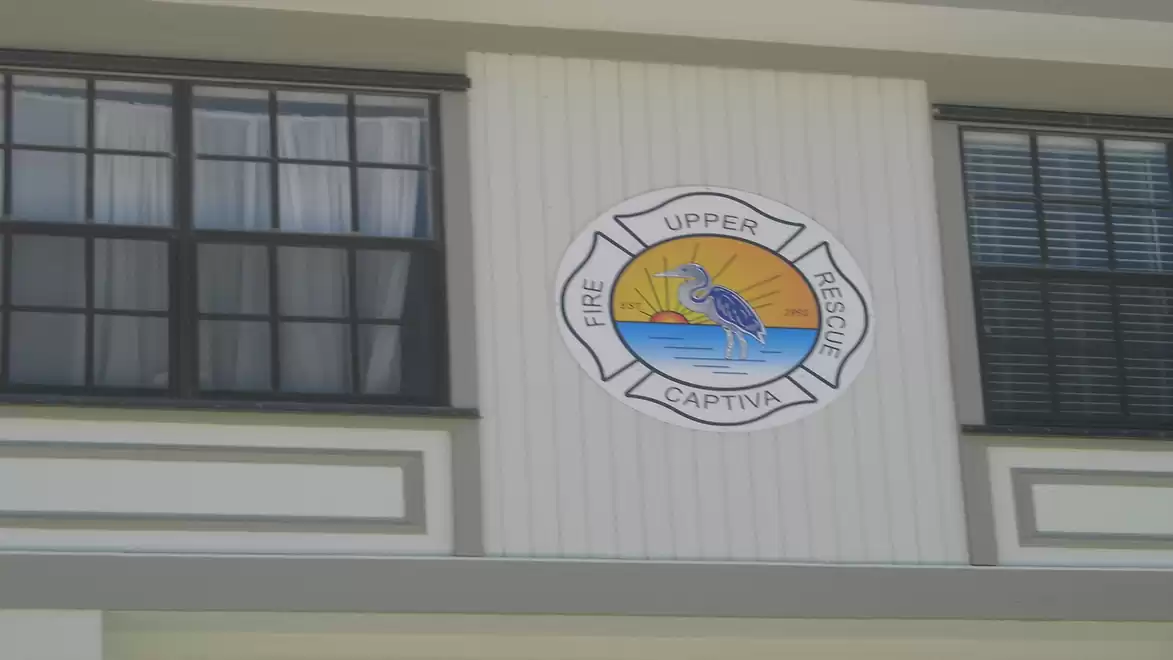 Gable of a building with an Upper Captiva Fire Rescue emblem between two windows.