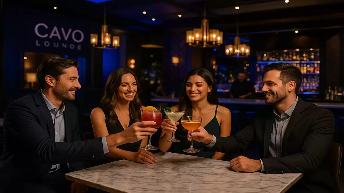 Four people toasting with cocktails in a stylish lounge.