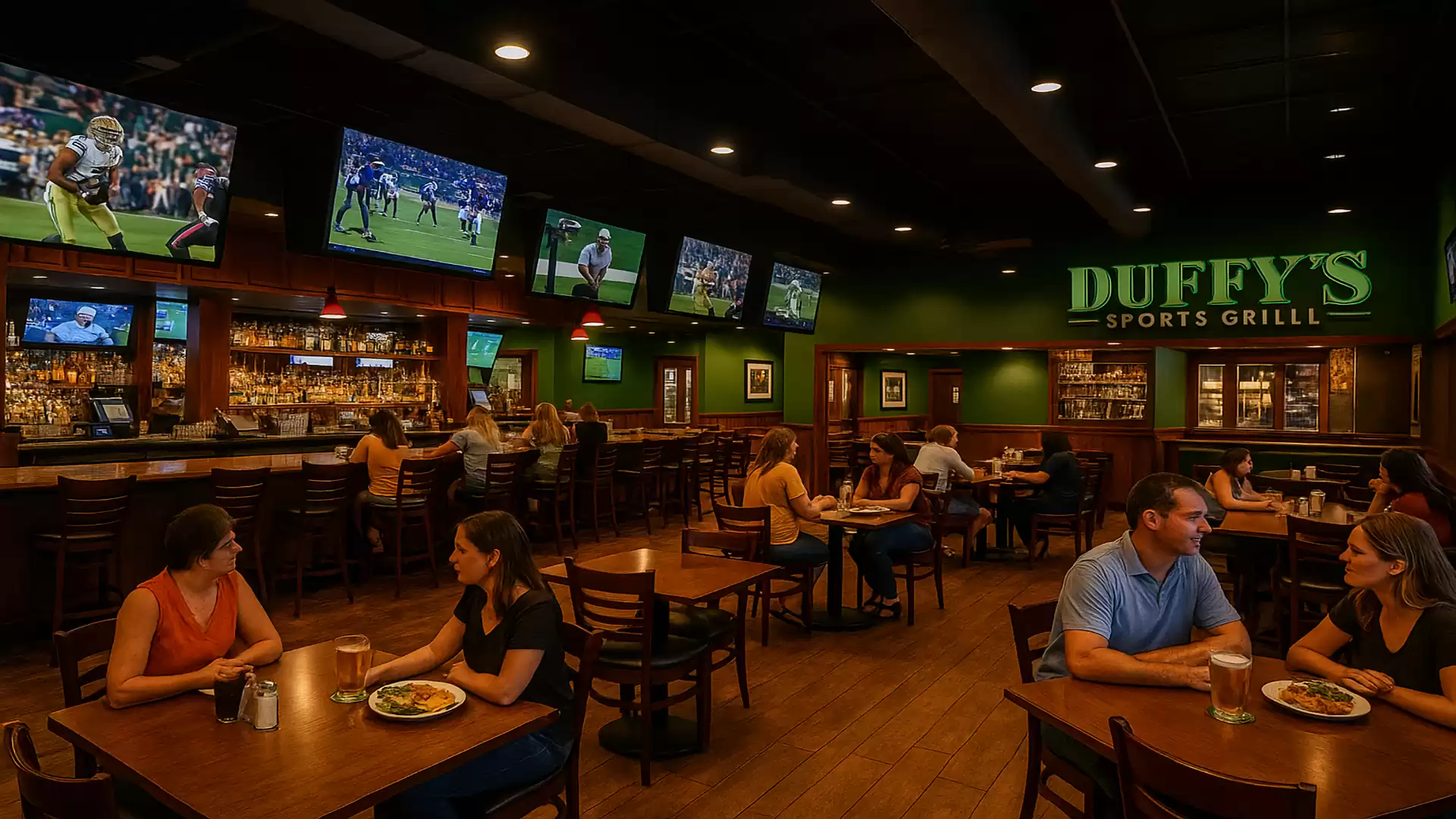 A busy sports restaurant with multiple TVs showing sporting events and guests eating and drinking at tables.