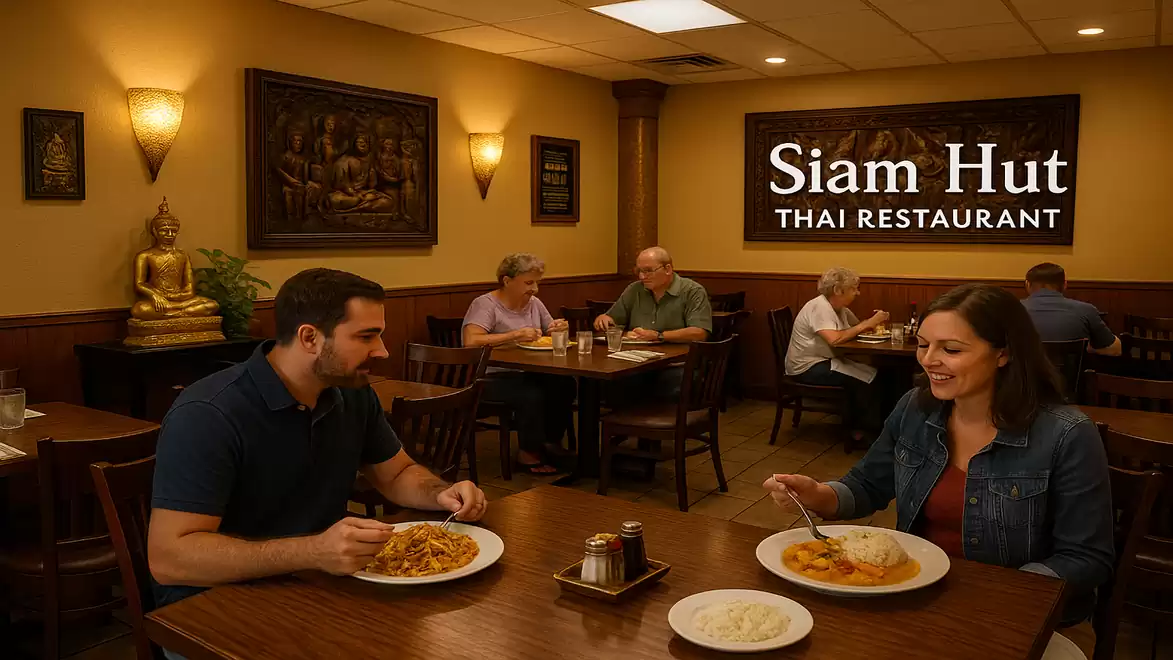 People dining at a cozy Thai restaurant called Siam Hut, with warm lighting and Thai decor.