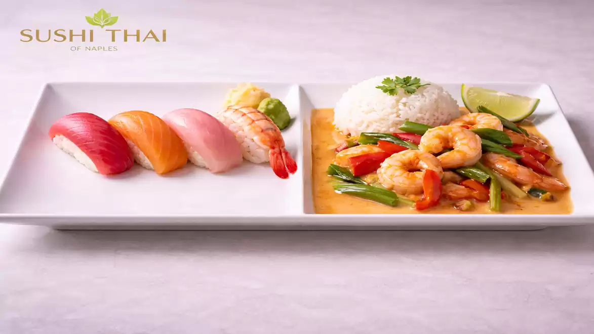 A rectangular plate with two sections. On the left are four pieces of Nigiri sushi with various toppings, on the right a Thai dish with shrimp, rice, and vegetables in red curry sauce.
