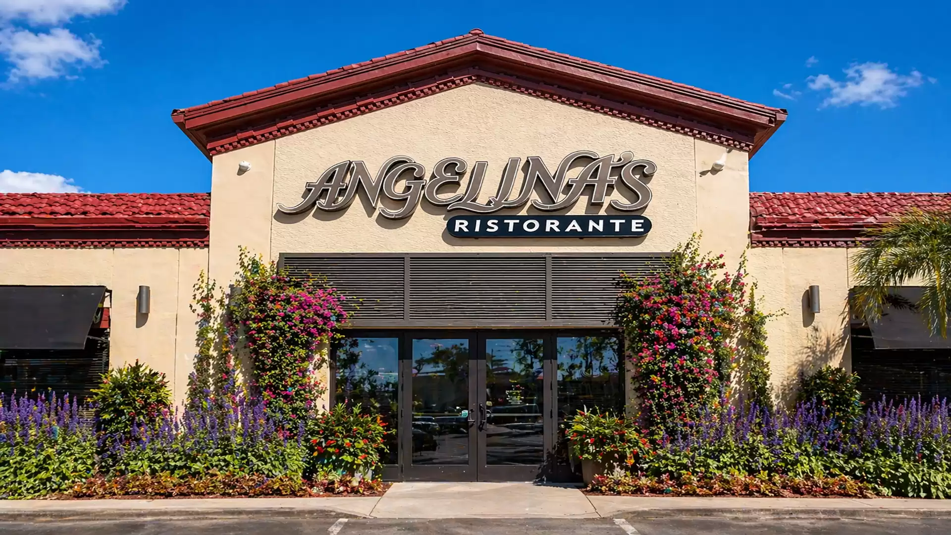 Exterior view of an Italian restaurant called Angelina's Ristorante with colorful flowers and blue sky