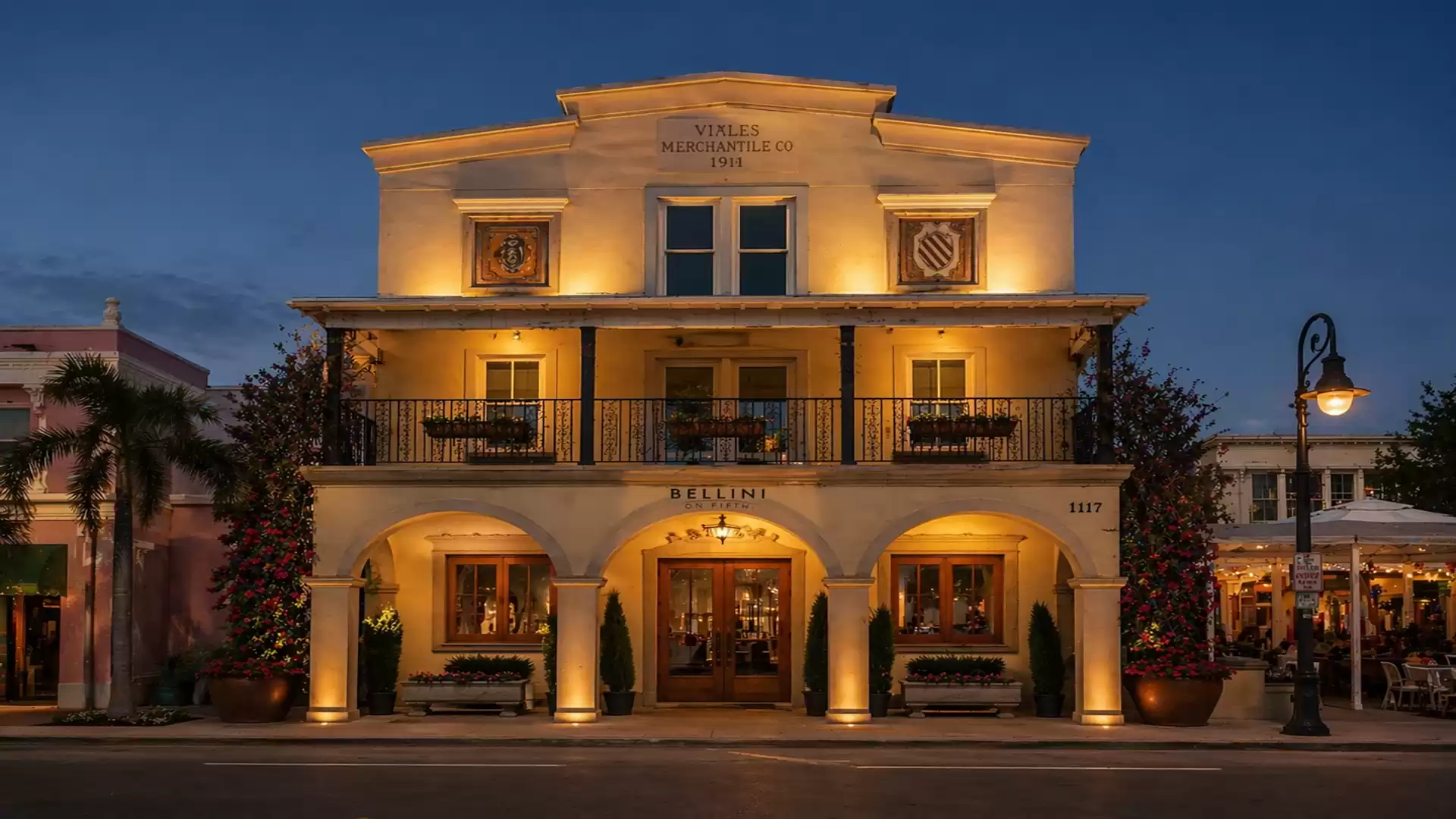 Historic building illuminated in the evening, featuring classical architecture and a symmetrical facade.