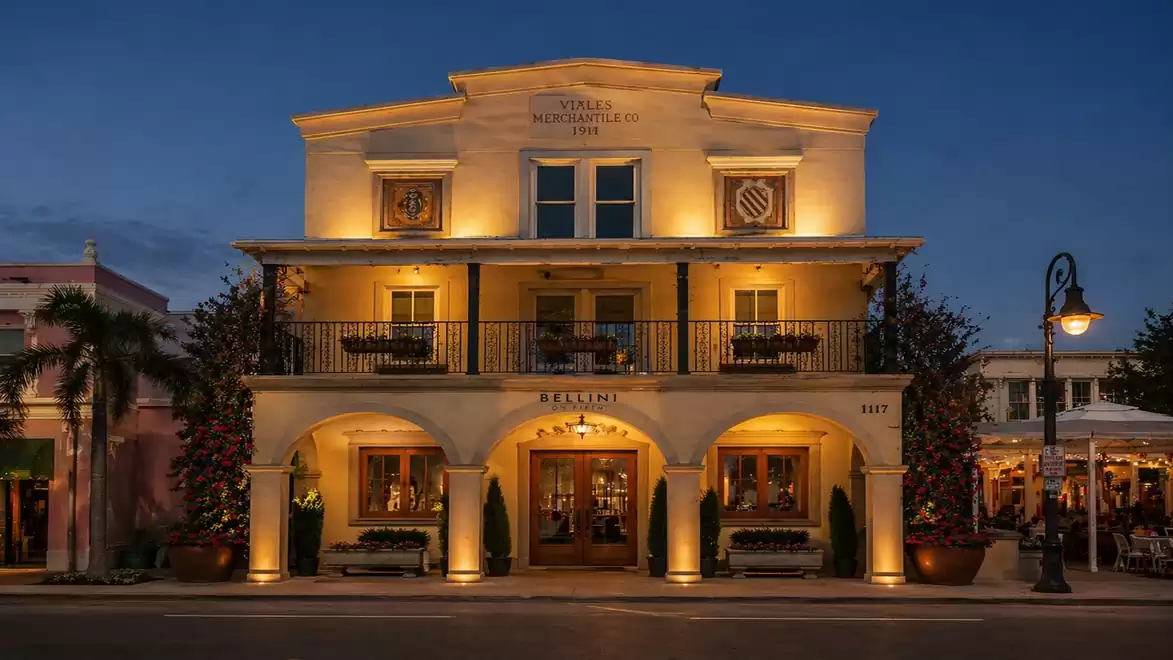 Historic building illuminated in the evening, featuring classical architecture and a symmetrical facade.