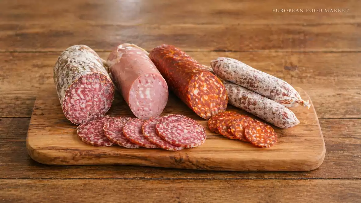 Various types of sausages on a wooden board, including salami and other cold cuts.