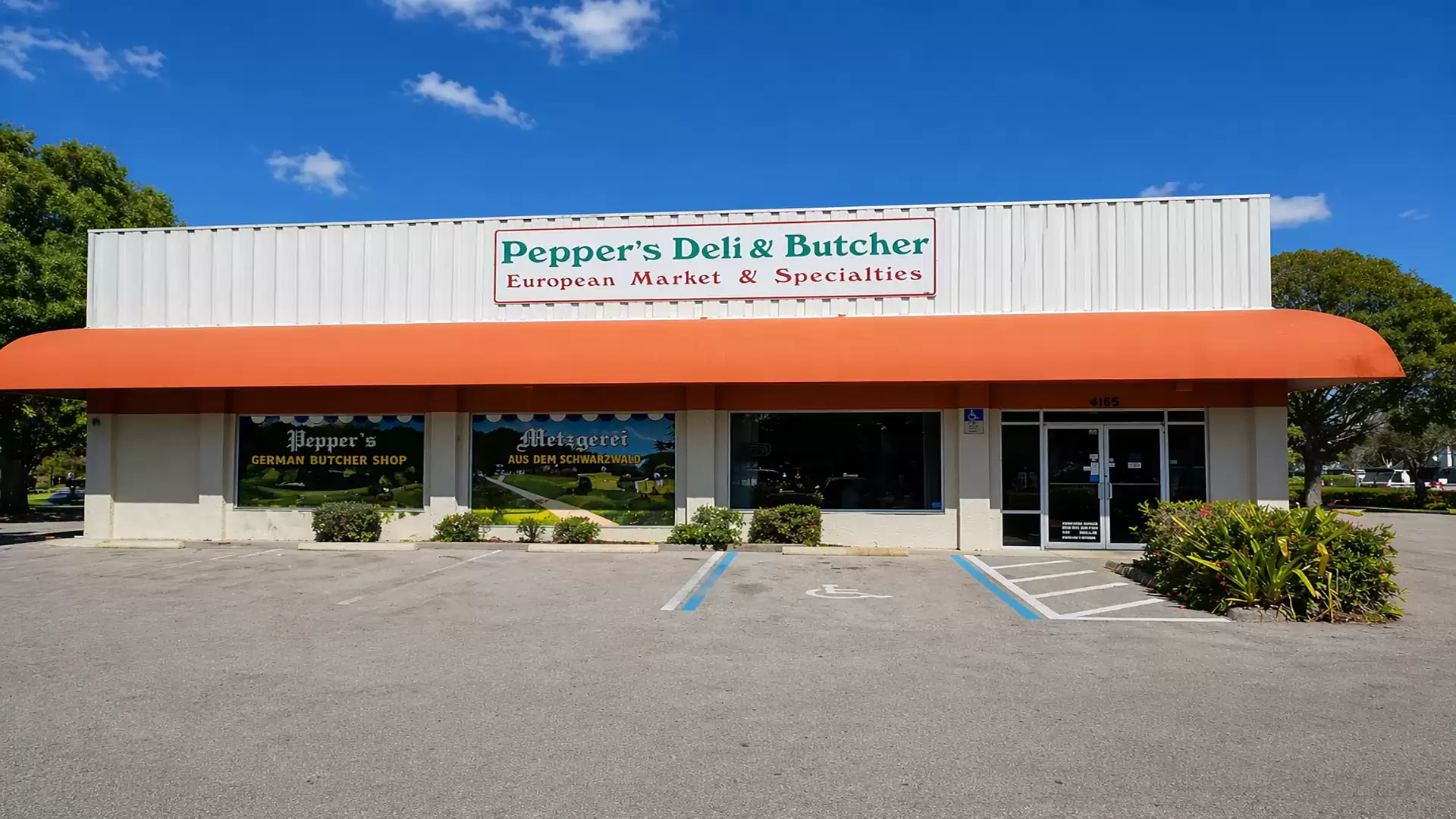 Exterior view of a store named Pepper's Deli & Butcher, European Market & Specialties, with a large awning and empty parking lot.