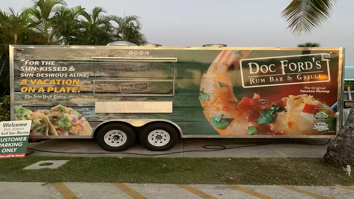 A food truck from Doc Ford's Rum Bar & Grill featuring seafood advertising and tropical design.