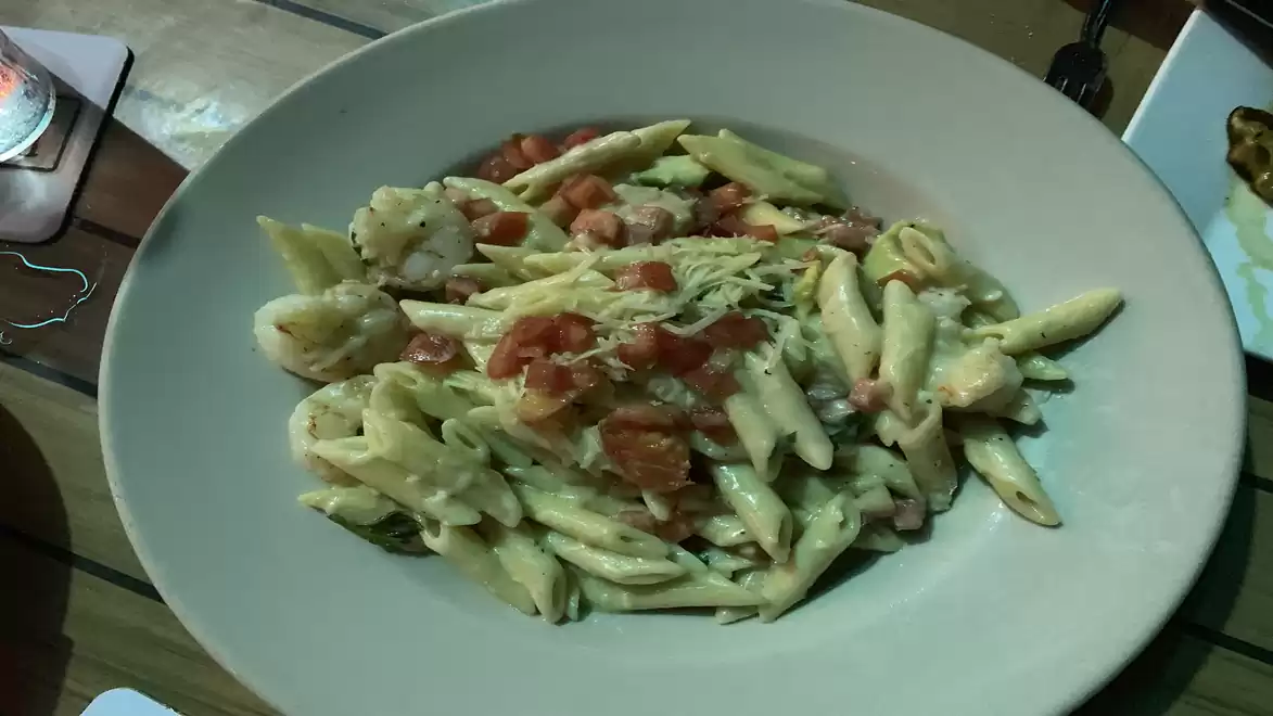 A plate of pasta in cream sauce, garnished with tomatoes and possibly cheese.