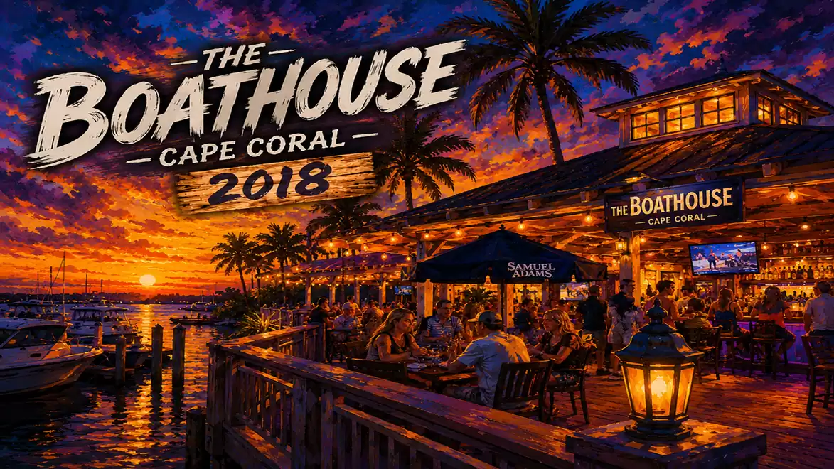 Sunset at the Boathouse in Cape Coral with palm trees and lit restaurant in the background.
