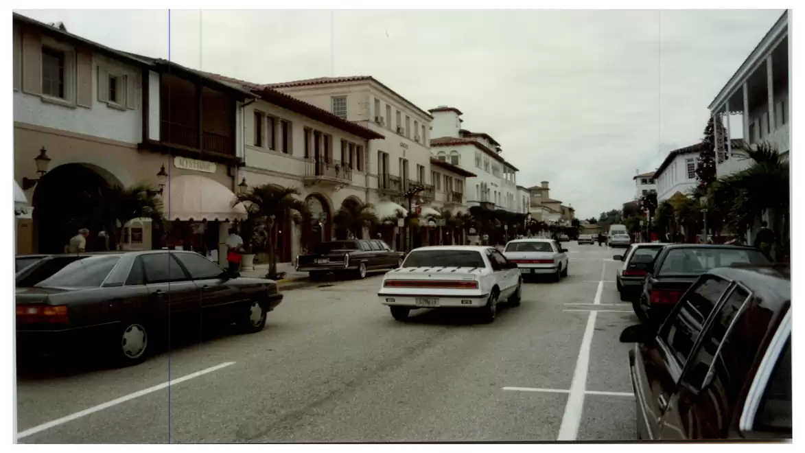 Street scene with cars and historic buildings along a busy main street.