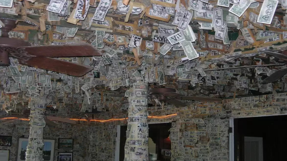 Interior view of a room with walls and ceiling covered in banknotes.