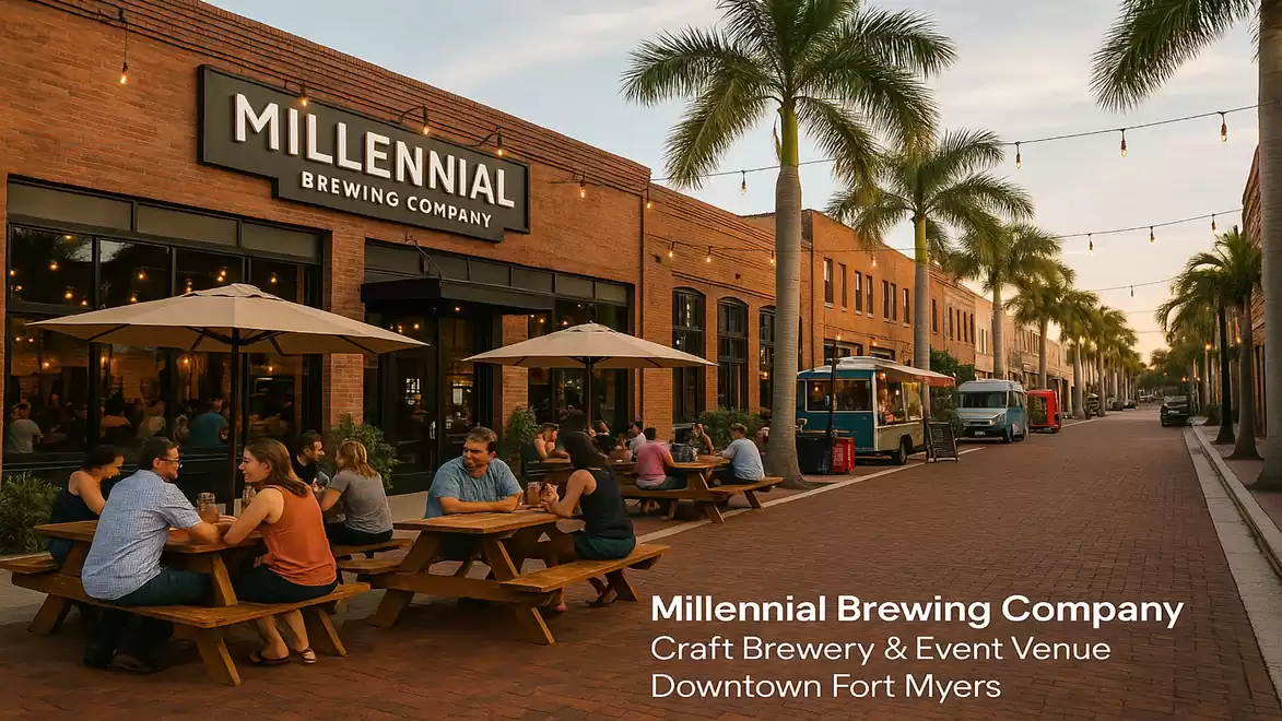 Outdoor area of Millennial Brewing Company with people sitting under umbrellas at wooden tables on a palm-lined street in Downtown Fort Myers.