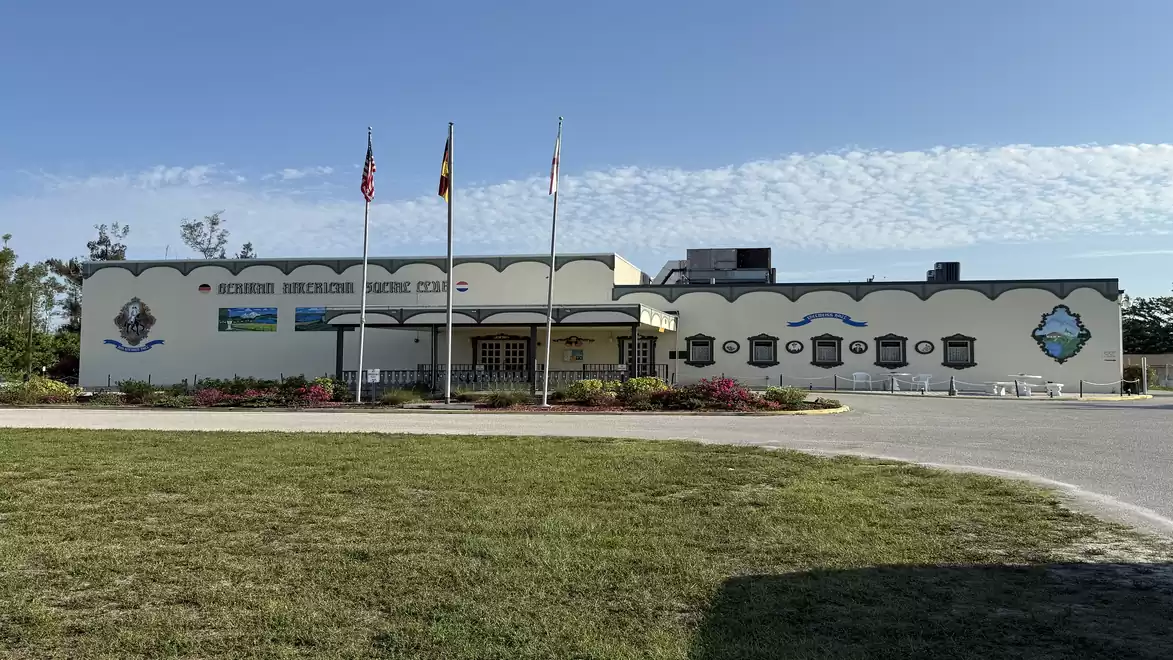 Exterior view of the Western Michigan Aviation Heritage Centre building on a clear day with waving flags in the foreground.