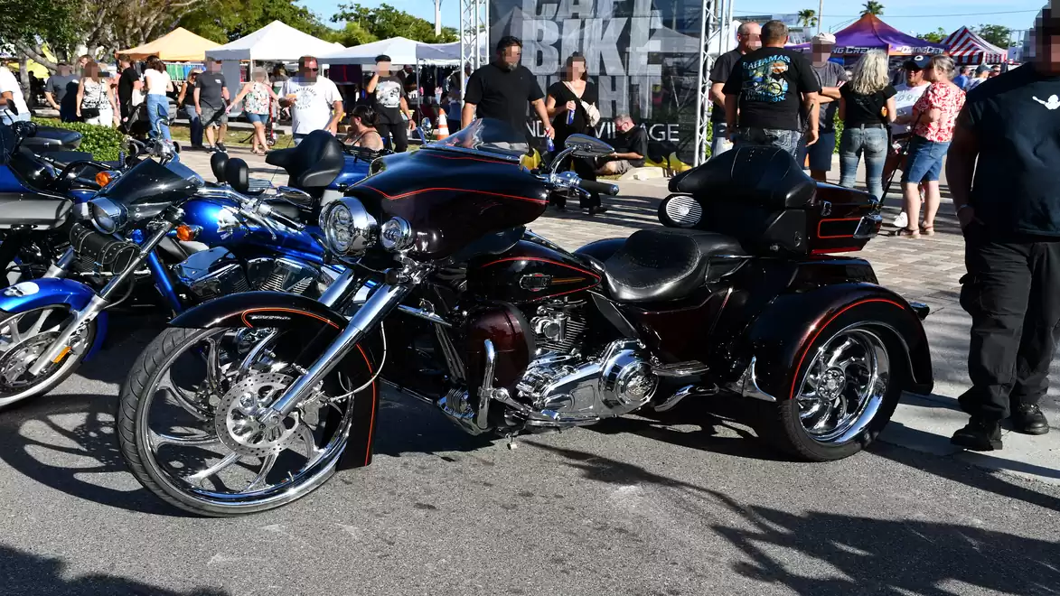 Several motorcycles and people at a bike event on a sunny day