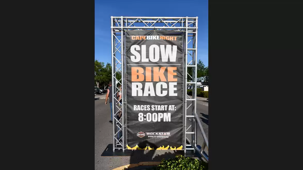 Poster for a slow bike race at 8 PM under a clear sky.