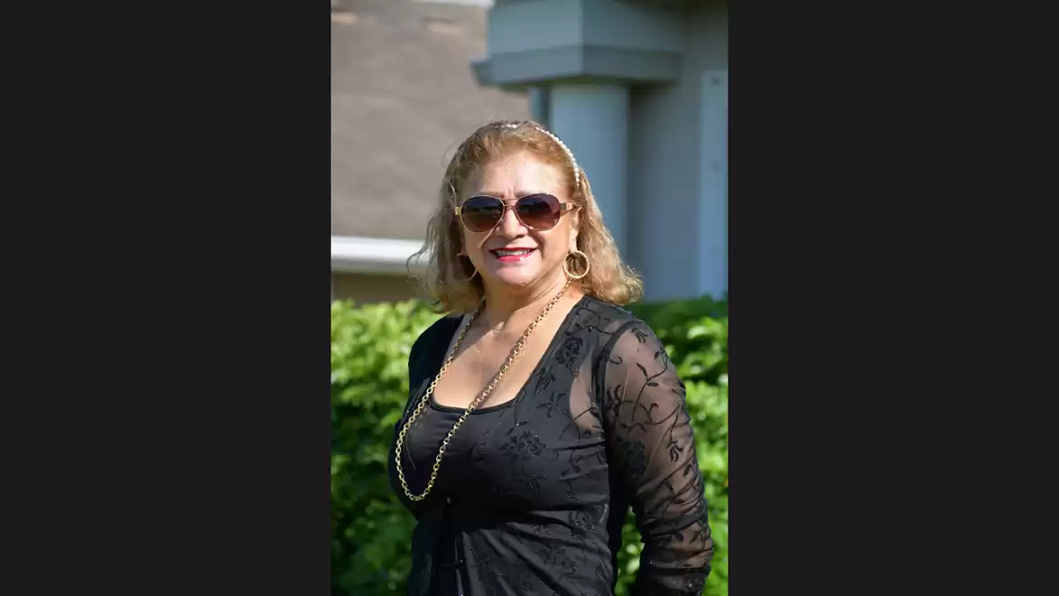 Woman in black dress with sunglasses outdoors