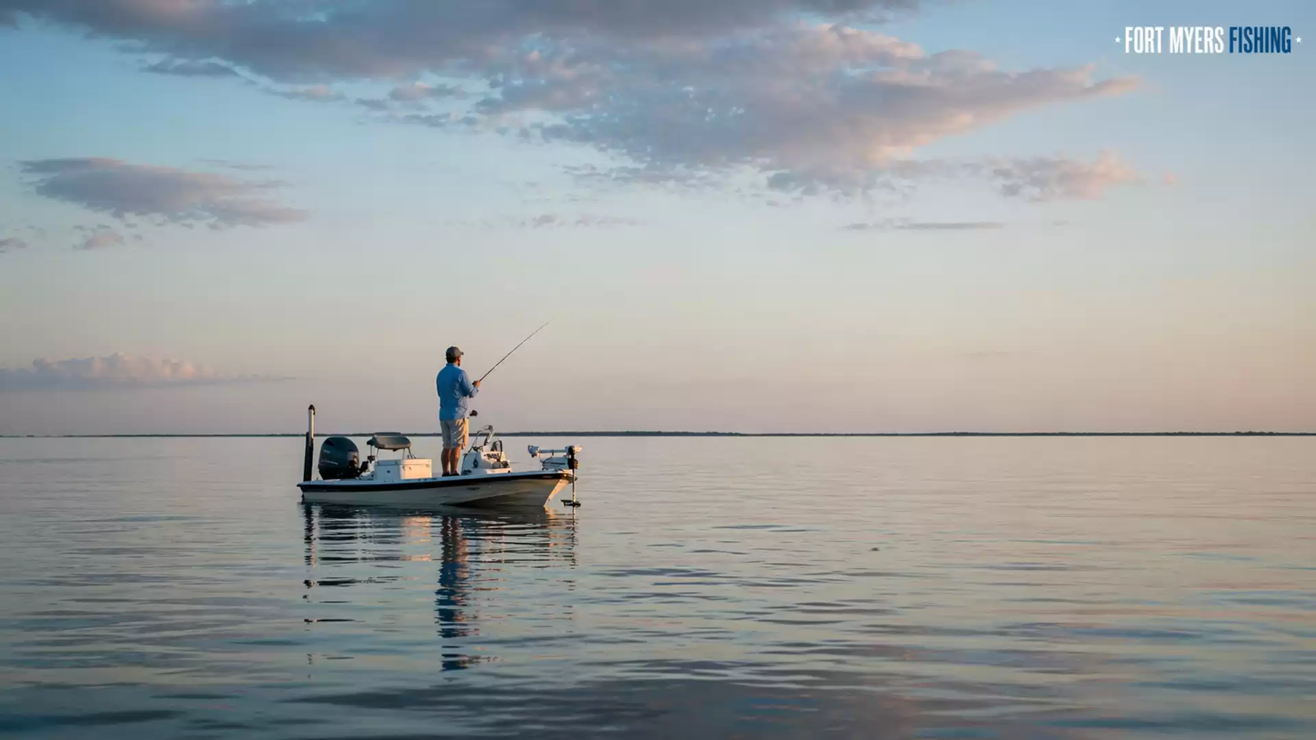 Person fishing on a boat at sunset on a calm sea.