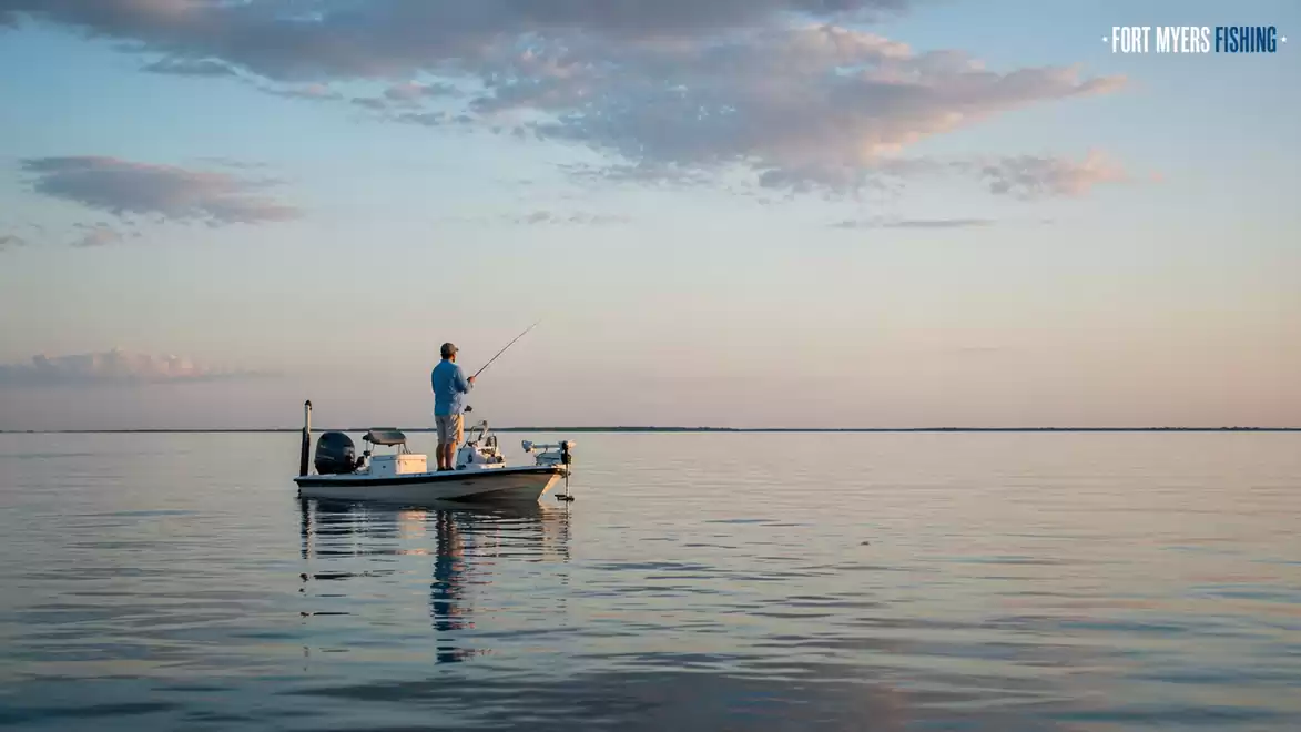 Person fishing on a boat at sunset on a calm sea.
