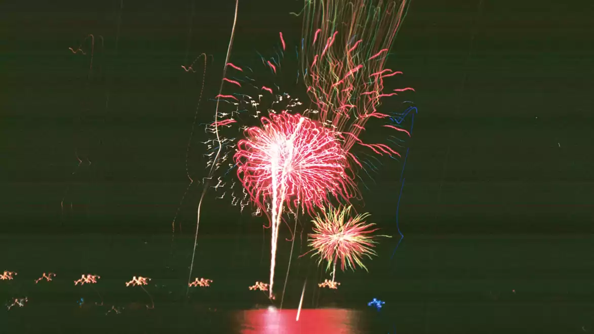 A stunning fireworks display over a dark sky, reflecting on the water.