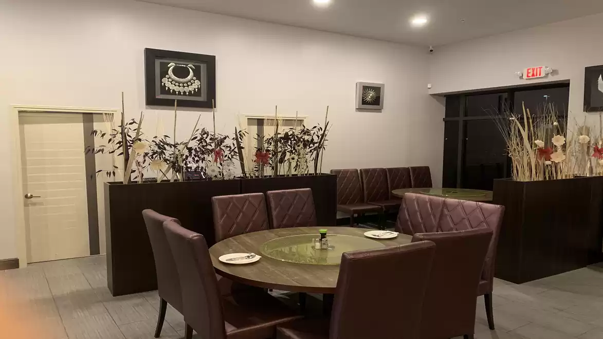 Elegant restaurant interior with modern brown chairs, artistically decorated tables, and stylish wall decorations.