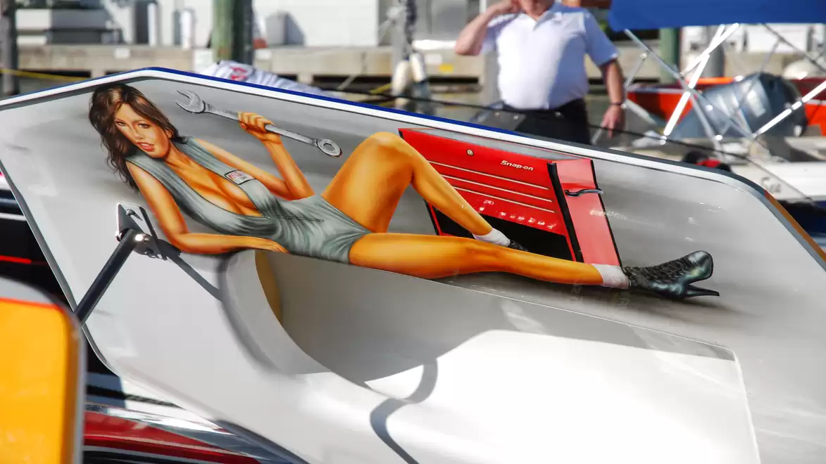 Artwork on a boat depicting a woman in a mechanic outfit posing with tools.