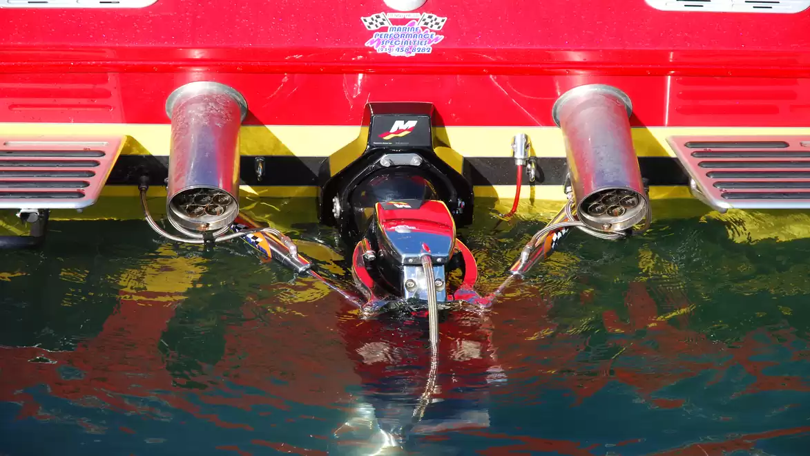 Rear view of a boat with two exhaust pipes in the water.