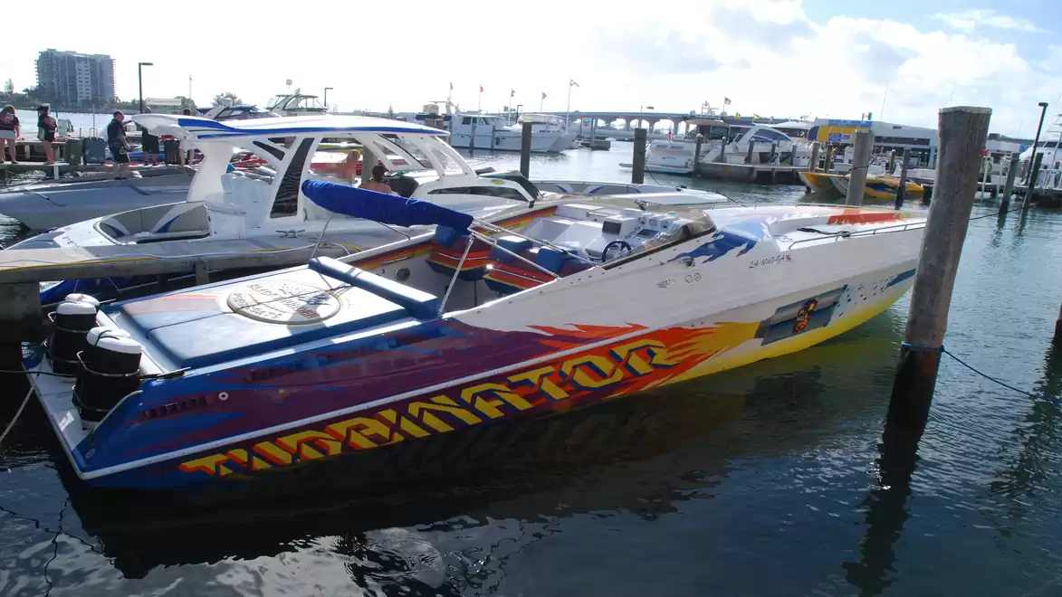 Colorful speedboat named 'Terminator', docked in a harbor under a clear sky.