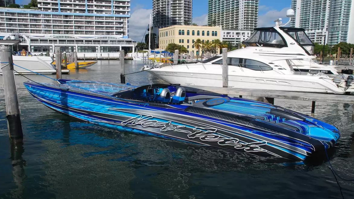 Fast blue motorboat in the marina in front of skyscrapers