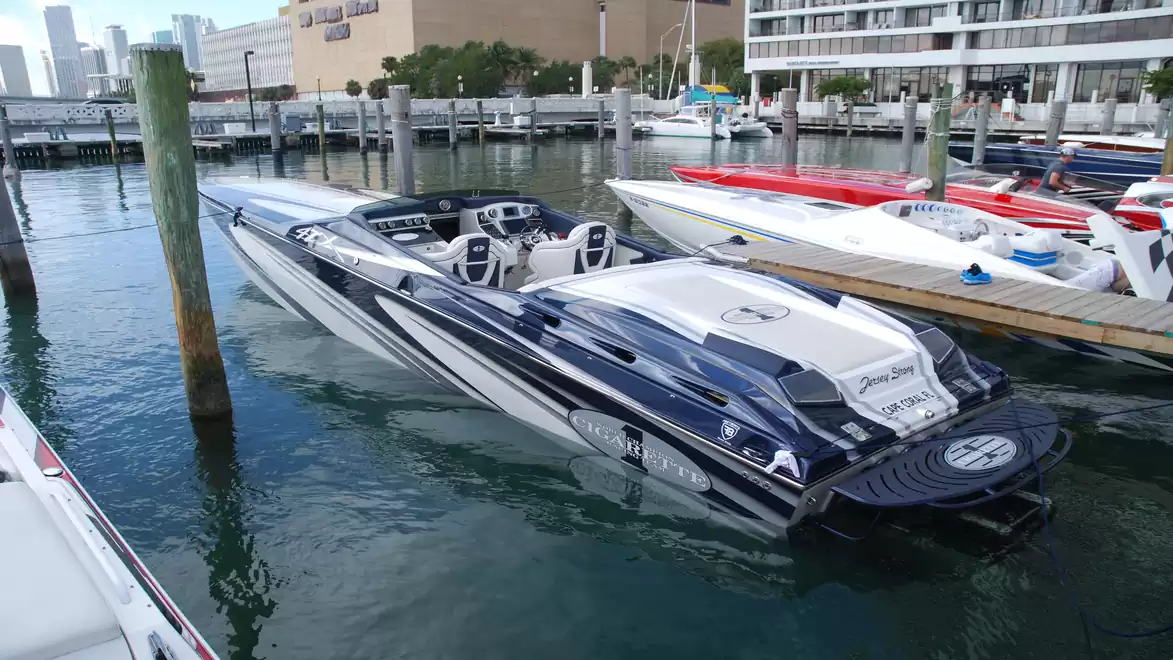 Fast motorboat in the harbor, surrounded by other boats and urban architecture.