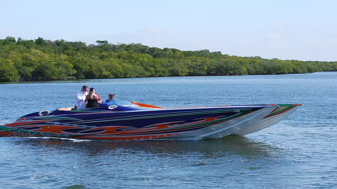 Fast speedboat on a calm river in a green landscape.