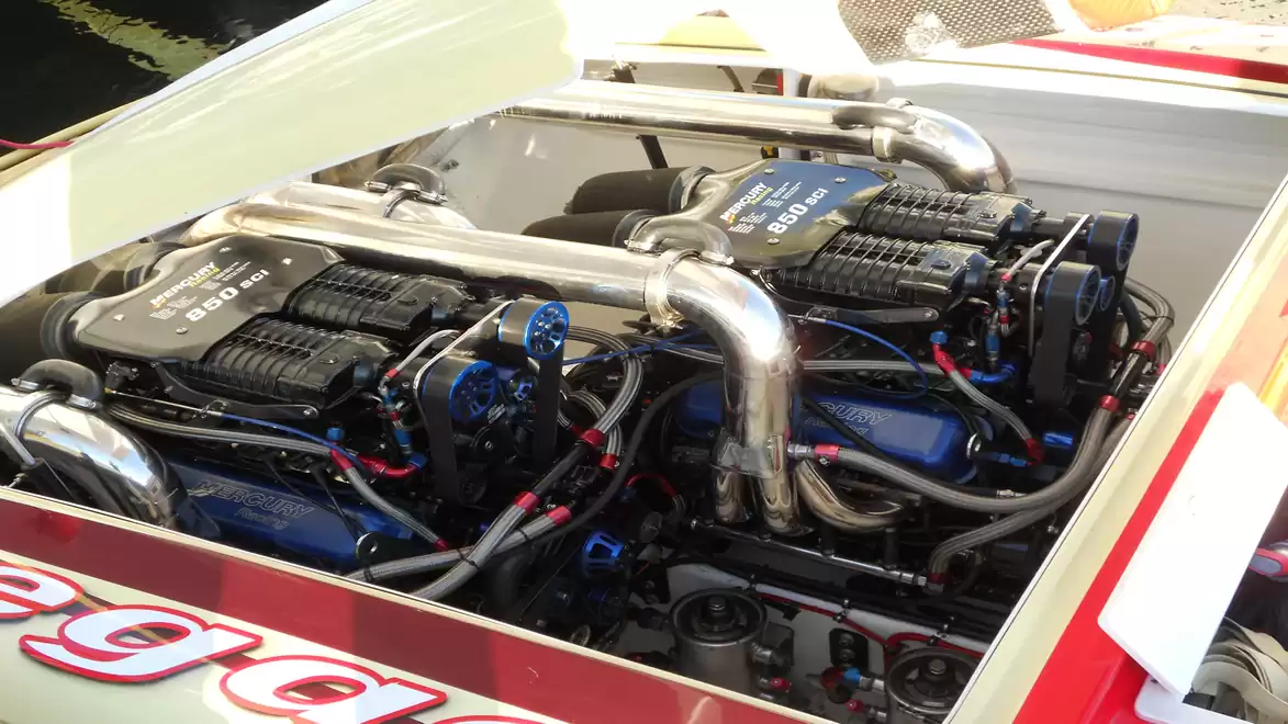 Close-up of a high-performance engine in a boat with shiny metal parts and complex components.