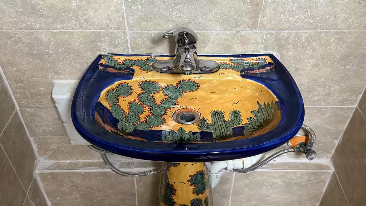 Colorful sink with cactus design in a bathroom.