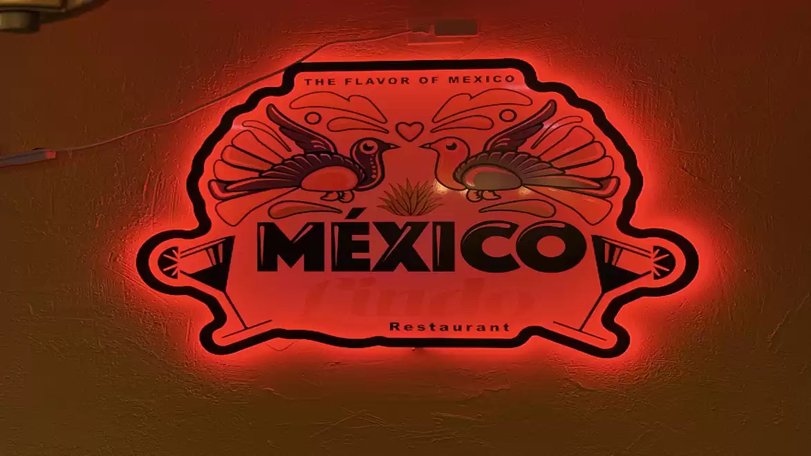 Illuminated sign of a Mexican restaurant featuring two stylized birds and the text 'Mexico'.