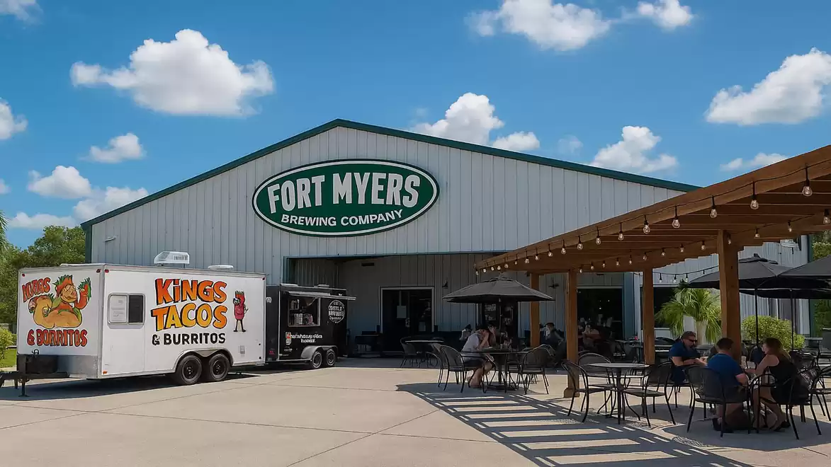 Fort Myers Brewing Company with 'Kings Tacos & Burritos' food truck and seating area on a sunny day.