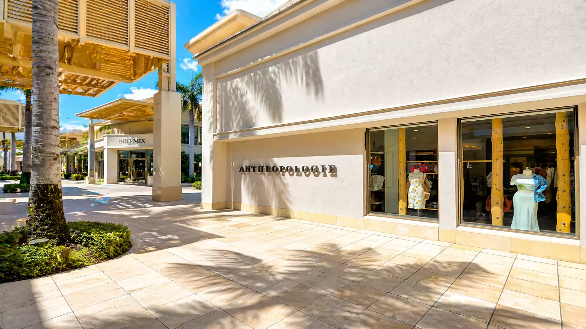 Exterior view of a shopping center with a store and showcase. The building displays the name 'Anthropologie'.
