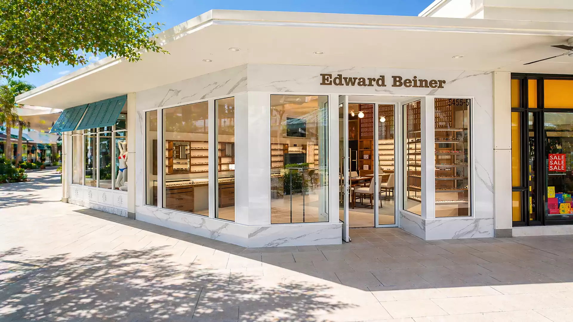 Exterior view of a modern eyewear store with large glass windows and clear signage.