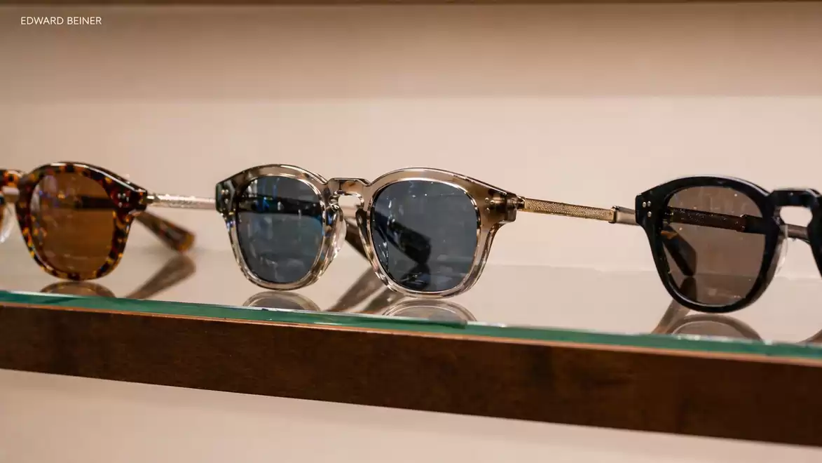 Three fashionable sunglasses placed side by side on a shelf, displayed in a stylish setting.