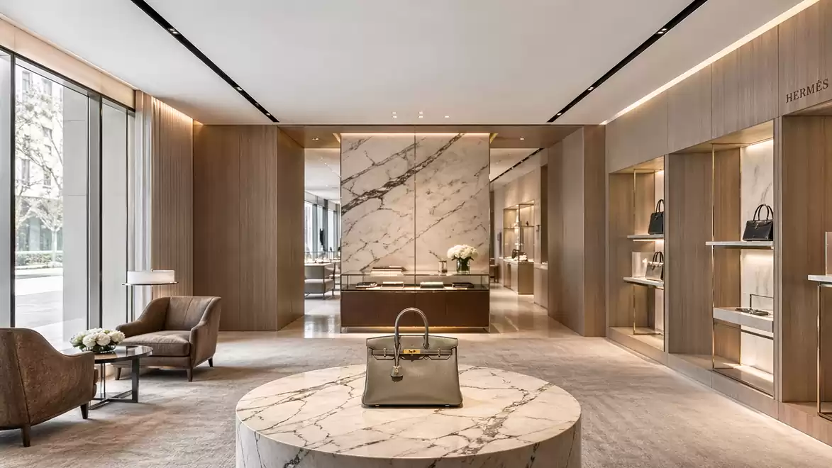 Luxurious handbag store with a marble table and elegant furniture.