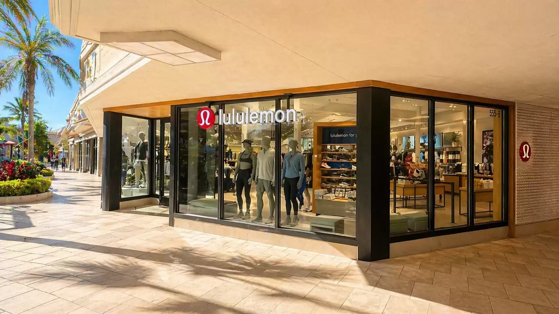 Lululemon storefront with mannequins and clothing displays in a shopping center on a sunny day.