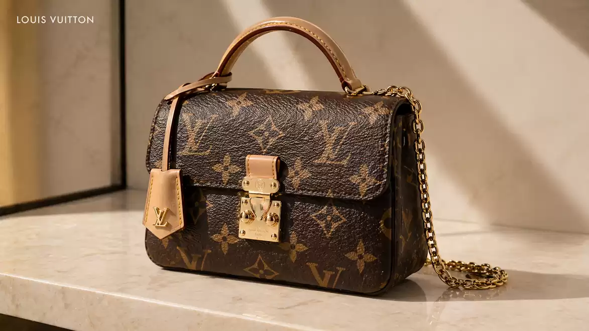 Luxurious leather handbag with a gold chain on a stylish marble table