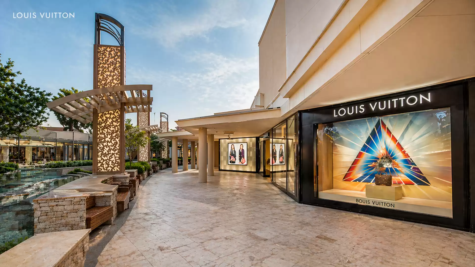 Shopping center with Louis Vuitton store and prismatic window display.