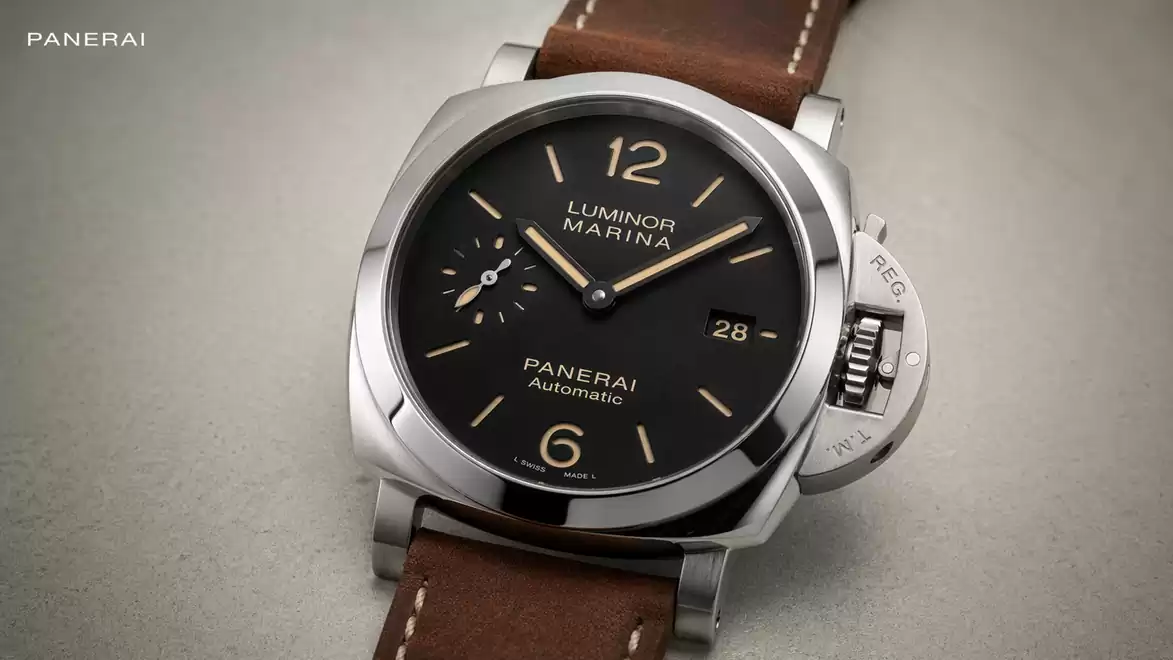 Close-up of a luxury watch with a brown leather strap and black dial, featuring the words Luminor Marina and Panerai Automatic.
