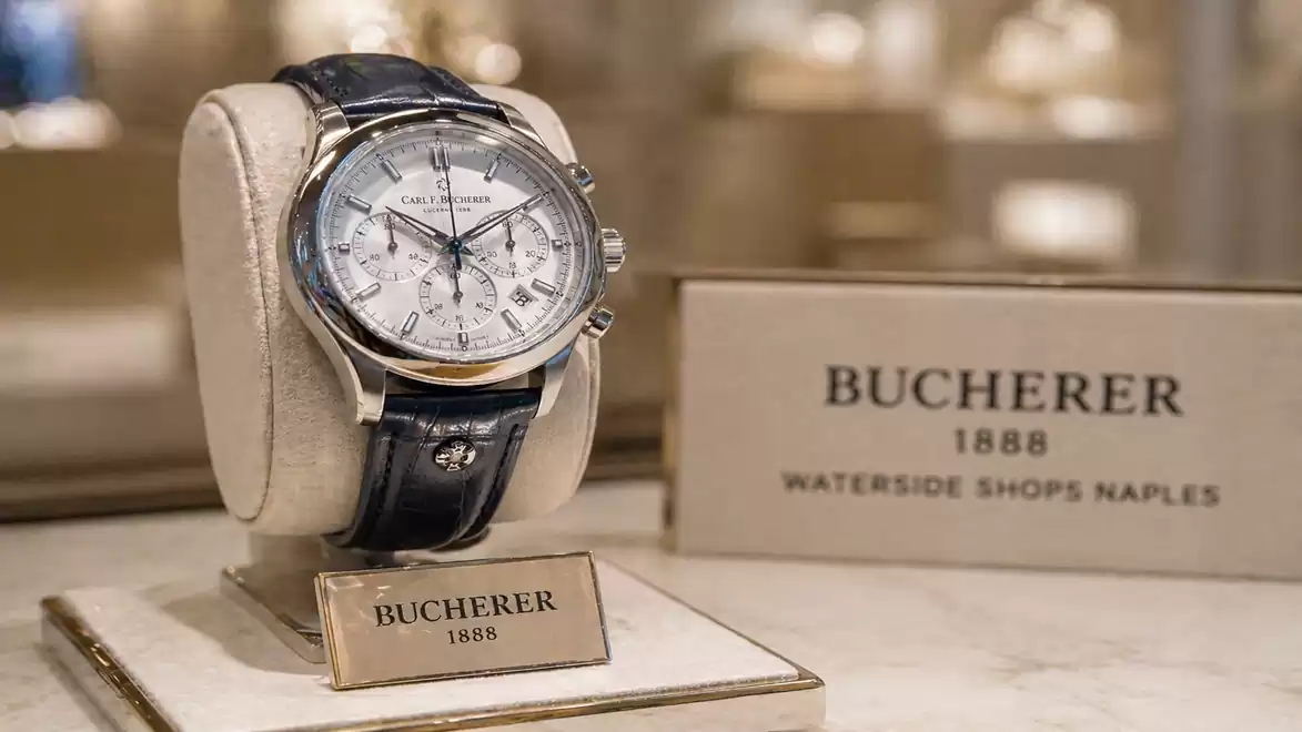 Luxury wristwatch on a display stand in a high-end watch and jewelry store with Bucherer branding.